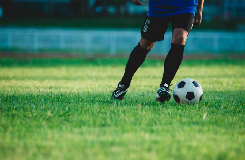 Jugador y balón de fútbol