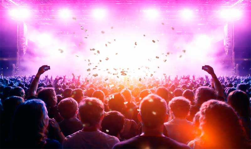 Concierto en vivo con multitud, luces brillantes y ambiente musical vibrante